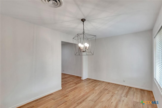 unfurnished dining area featuring wood-type flooring and a chandelier