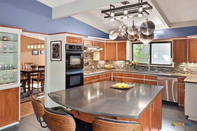 kitchen featuring stainless steel appliances, sink, tasteful backsplash, and vaulted ceiling with beams