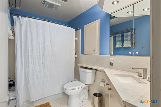 full bathroom with shower / bath combo, toilet, tile patterned floors, tile walls, and vanity