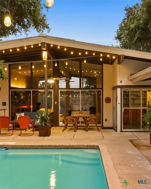 pool at dusk with a patio