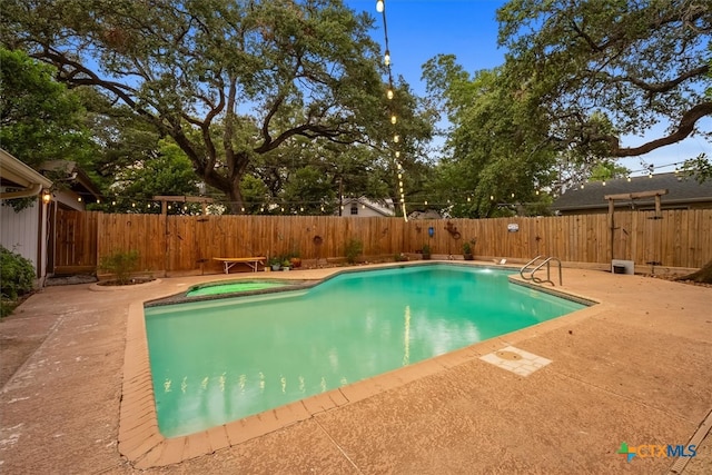 view of swimming pool featuring a patio area and an in ground hot tub