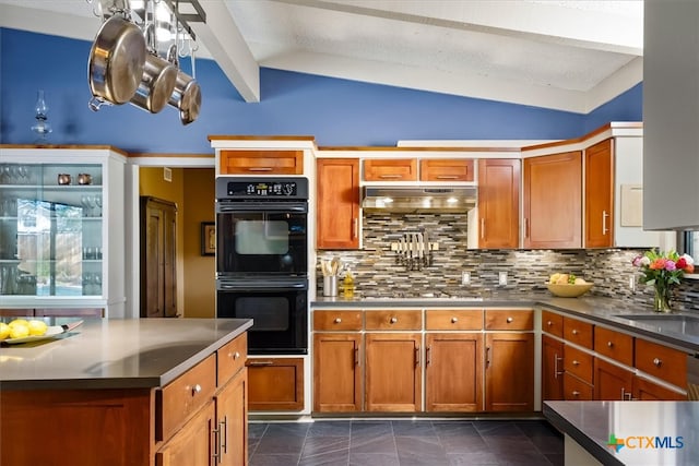 kitchen with sink, dark tile patterned floors, tasteful backsplash, lofted ceiling, and double oven