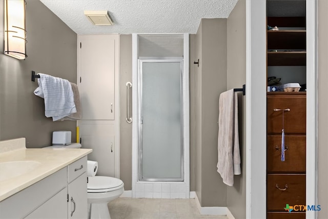 bathroom featuring toilet, tile patterned flooring, a textured ceiling, an enclosed shower, and vanity