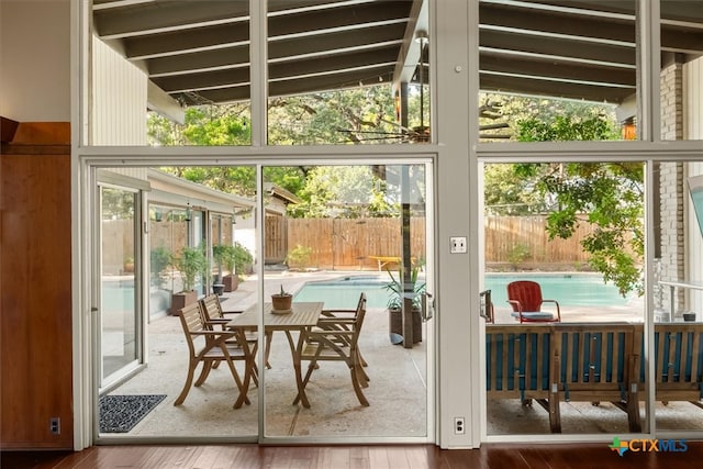 sunroom / solarium featuring plenty of natural light and lofted ceiling