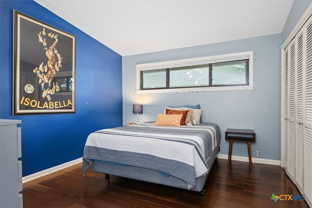 bedroom with hardwood / wood-style flooring, vaulted ceiling, and a closet