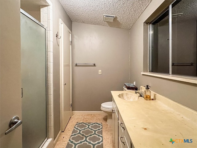 bathroom with toilet, tile patterned flooring, a textured ceiling, an enclosed shower, and vanity