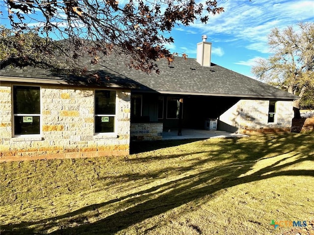 view of side of property with a patio and a lawn