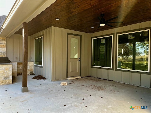 entrance to property featuring ceiling fan, area for grilling, and a patio