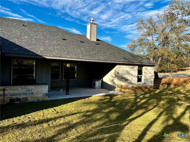 back of house featuring a patio area and a yard