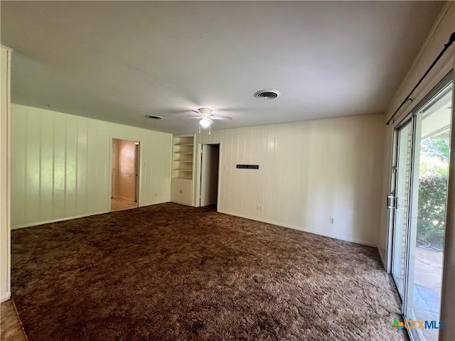 2809 Forest Trl, Temple, TX 76502 - carpeted spare room featuring a ceiling fan, baseboards, and wooden walls