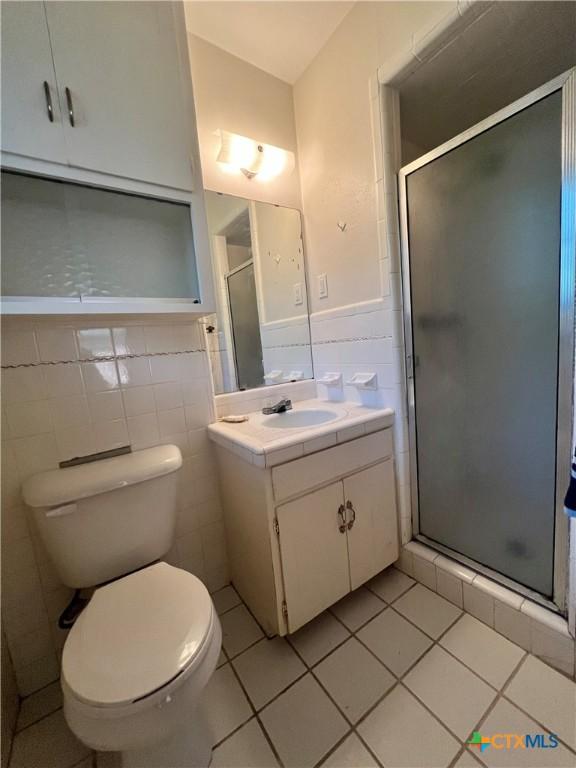 2809 Forest Trl, Temple, TX 76502 - bathroom with tile walls, vanity, toilet, a stall shower, and tile patterned floors