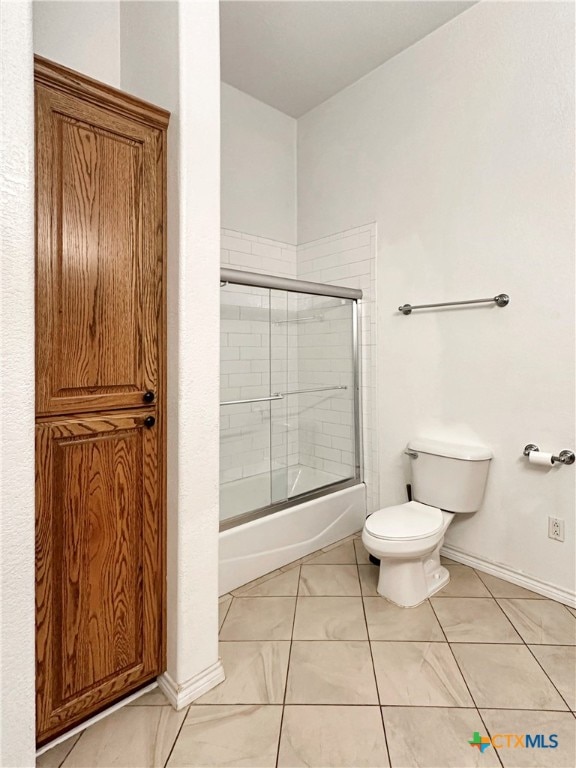 bathroom with enclosed tub / shower combo and toilet