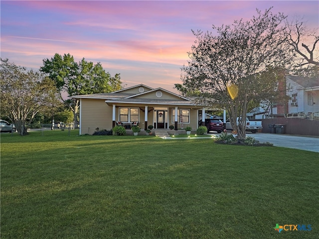 view of front of property featuring a porch and a lawn