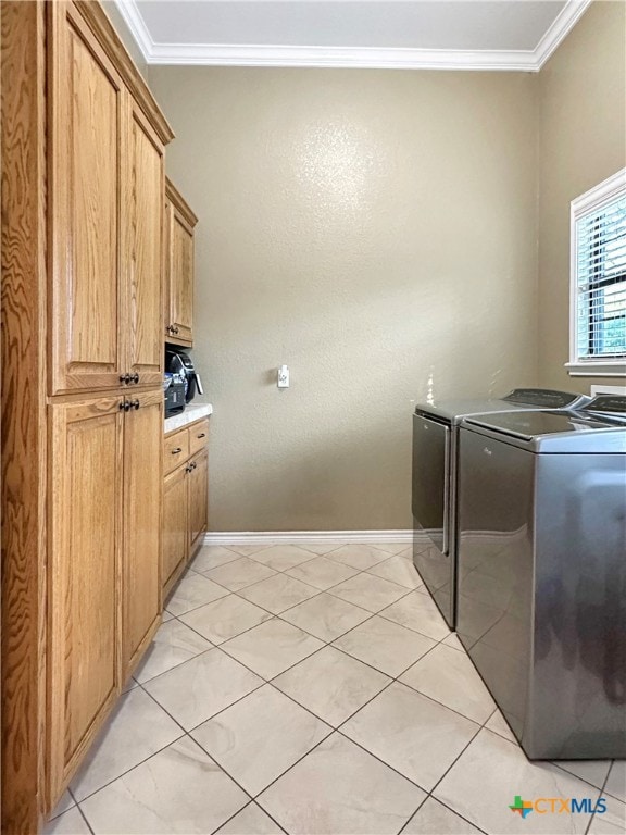 laundry room featuring ornamental molding, cabinets, and washing machine and clothes dryer