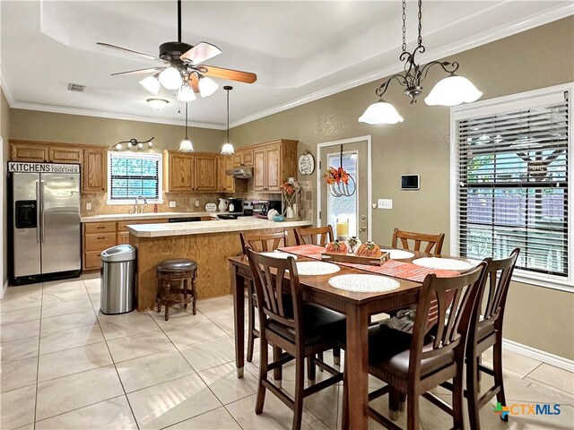 dining area featuring light tile patterned flooring, ceiling fan, sink, and ornamental molding