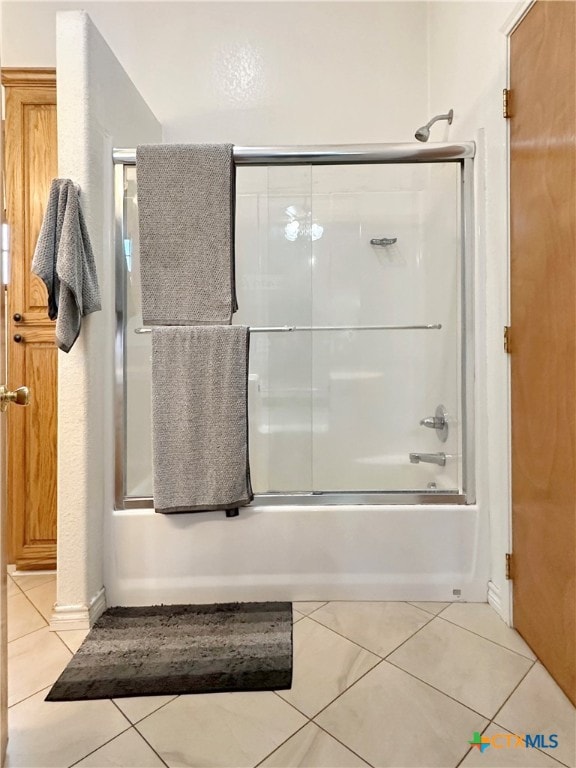 bathroom featuring tile patterned floors and enclosed tub / shower combo