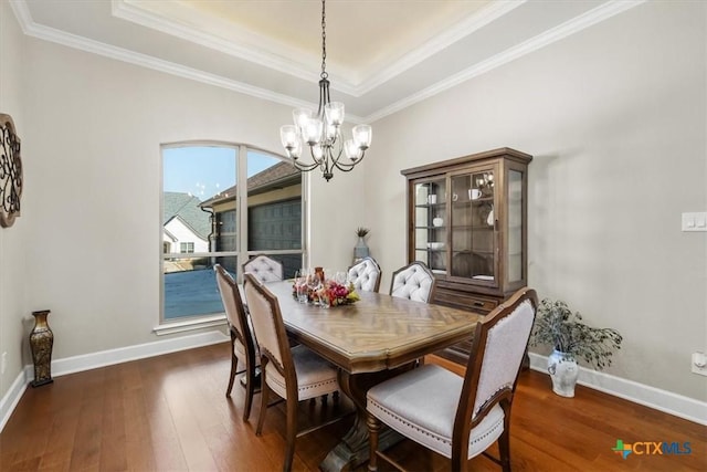 dining space featuring crown molding, an inviting chandelier, and dark hardwood / wood-style flooring