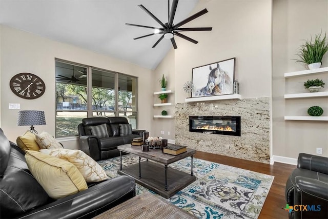 living room with built in shelves, ceiling fan, dark wood-type flooring, a fireplace, and high vaulted ceiling