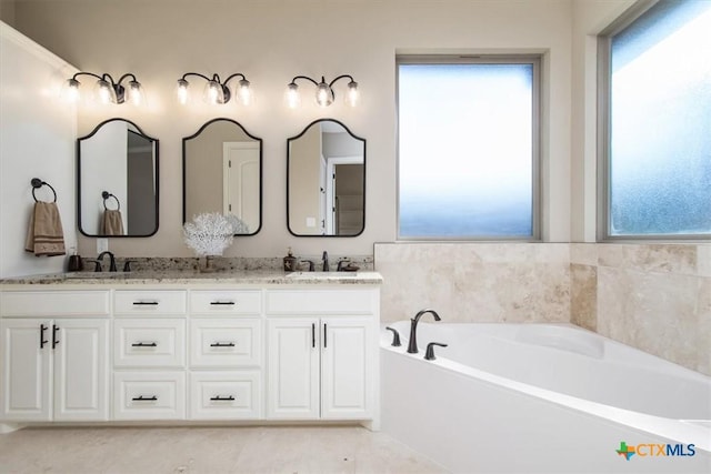 bathroom with vanity, a bathtub, and plenty of natural light