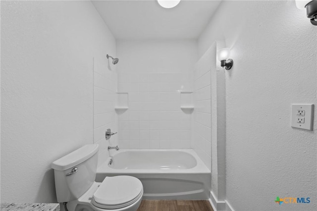 full bath featuring toilet, wood finished floors, and shower / bathtub combination