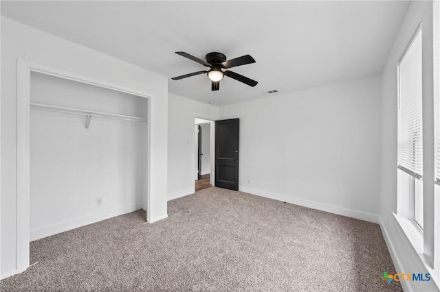 unfurnished bedroom featuring visible vents, a ceiling fan, a closet, carpet flooring, and baseboards