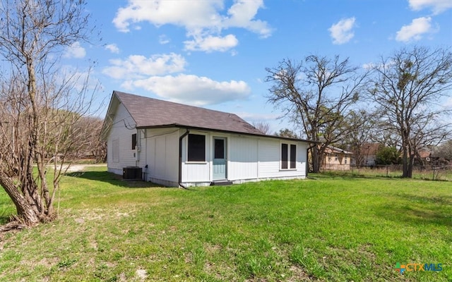 rear view of property featuring a yard, cooling unit, and fence