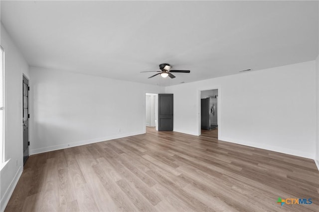 spare room with visible vents, baseboards, light wood-style floors, and a ceiling fan