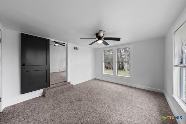 carpeted empty room featuring visible vents, plenty of natural light, and baseboards