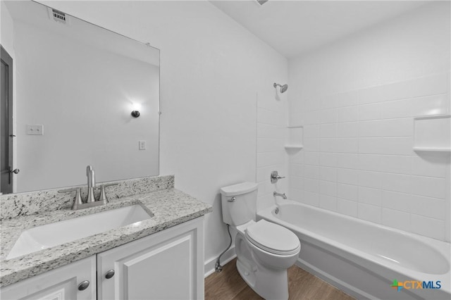 bathroom featuring washtub / shower combination, toilet, wood finished floors, and vanity