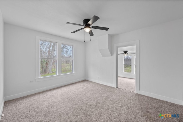 interior space featuring a wealth of natural light, baseboards, and carpet flooring