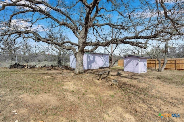 view of yard with an outbuilding, a storage shed, and a fenced backyard