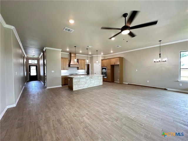 6132 Messina Dr, Temple, TX 76502 - kitchen with premium range hood, open floor plan, wood finished floors, ceiling fan, and light countertops