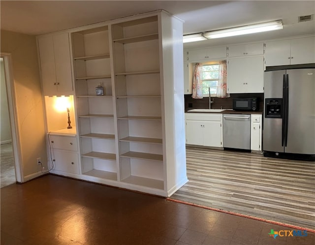 interior space featuring dark hardwood / wood-style floors, white cabinetry, sink, and appliances with stainless steel finishes