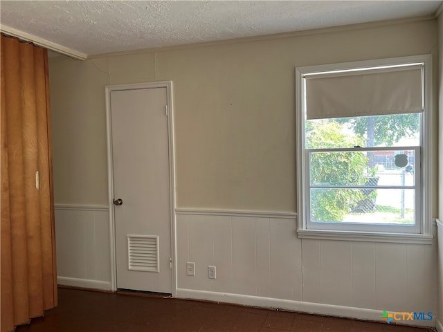 spare room with wood walls and a textured ceiling