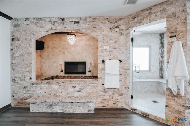 bathroom featuring visible vents, a shower stall, and wood finished floors