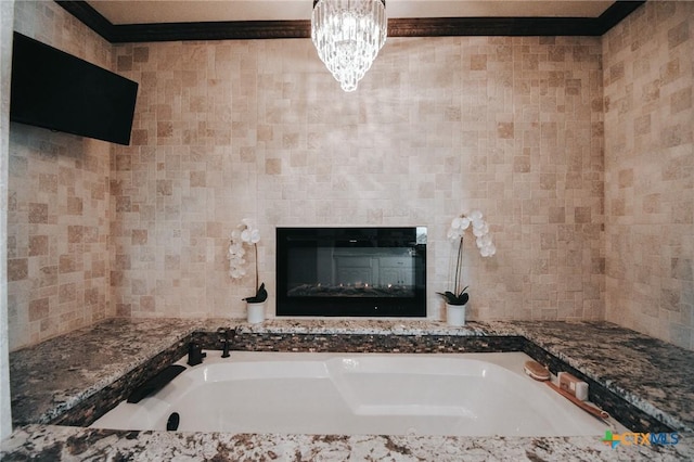 bathroom featuring a chandelier, a glass covered fireplace, and a bath