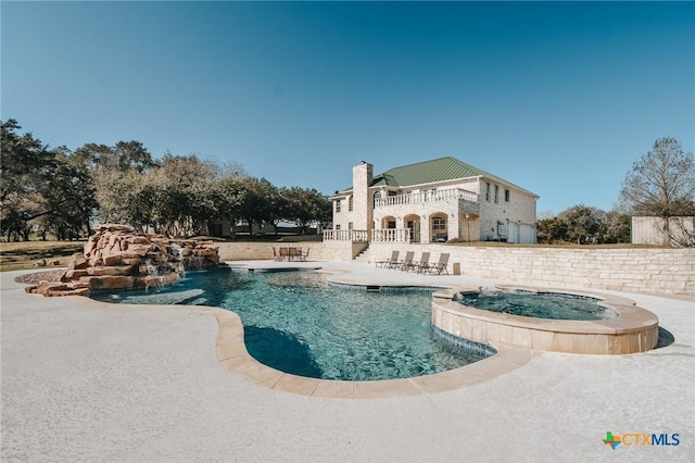 view of swimming pool with a patio area and a pool with connected hot tub