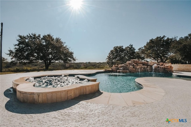 view of pool with a pool with connected hot tub