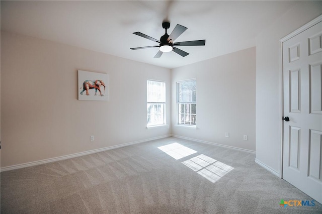 spare room with carpet flooring, a ceiling fan, and baseboards