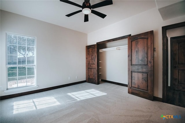 unfurnished bedroom featuring light carpet, a ceiling fan, baseboards, and a closet