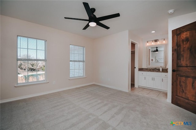 unfurnished bedroom featuring recessed lighting, a ceiling fan, light carpet, connected bathroom, and baseboards