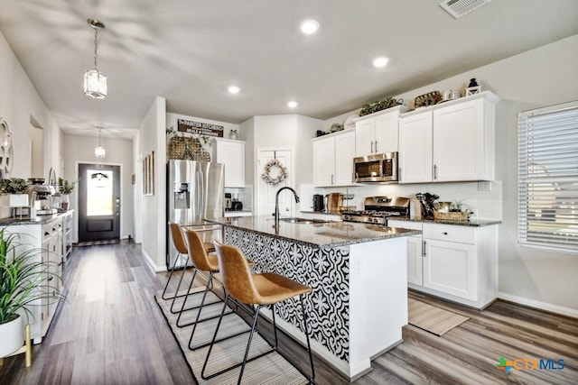 31696 Bard Ln, Bulverde, TX 78163 - kitchen featuring appliances with stainless steel finishes, a sink, wood finished floors, baseboards, and recessed lighting