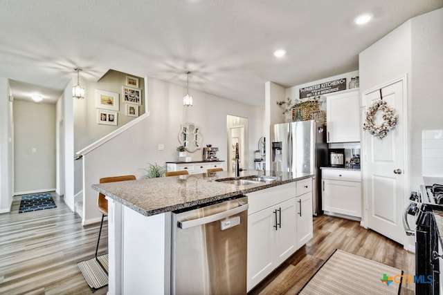 31696 Bard Ln, Bulverde, TX 78163 - kitchen with stainless steel appliances, a sink, white cabinetry, a center island with sink, and recessed lighting