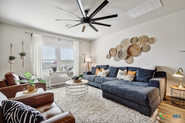 31696 Bard Ln, Bulverde, TX 78163 - living room with wood finished floors, a ceiling fan, baseboards, and a textured ceiling