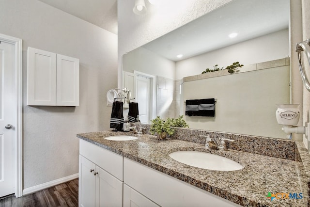 31696 Bard Ln, Bulverde, TX 78163 - bathroom featuring wood finished floors, baseboards, double vanity, and a textured wall