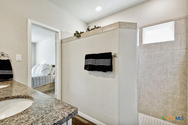 31696 Bard Ln, Bulverde, TX 78163 - ensuite bathroom with vanity, wood finished floors, baseboards, and tiled shower