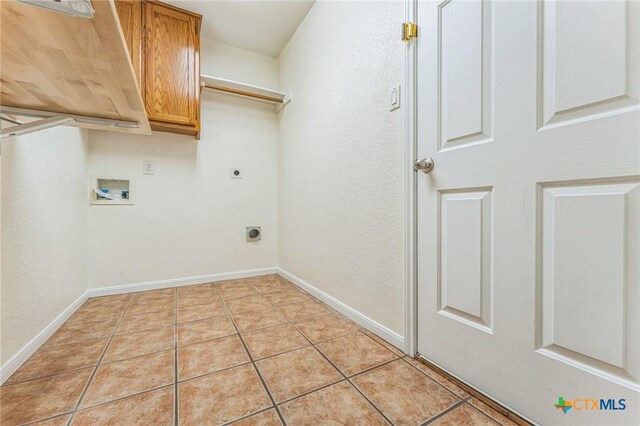 3302 Colorado Dr, Copperas Cove, TX 76522 - laundry area with cabinet space, electric dryer hookup, hookup for a washing machine, light tile patterned floors, and baseboards