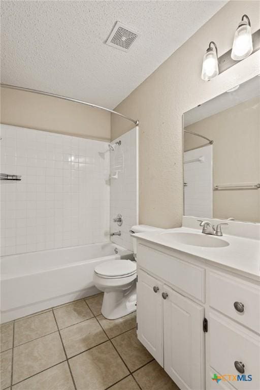 full bathroom with toilet, vanity, tile patterned flooring, tiled shower / bath, and a textured ceiling