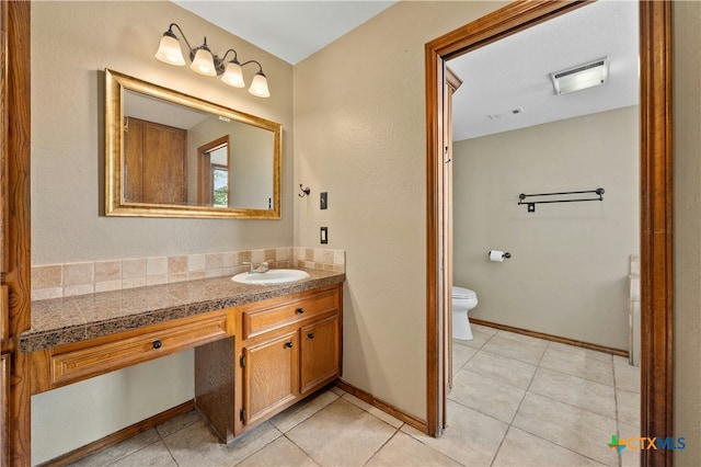 bathroom with toilet, tile patterned floors, and vanity