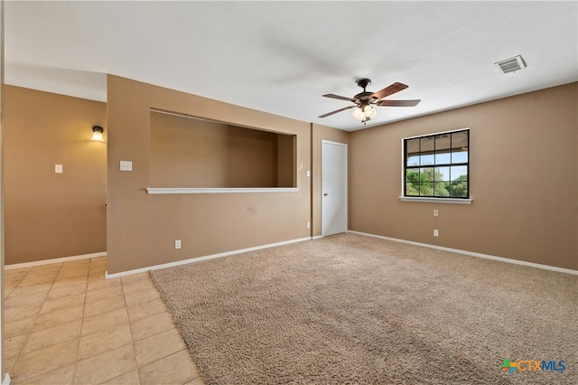 tiled spare room featuring ceiling fan